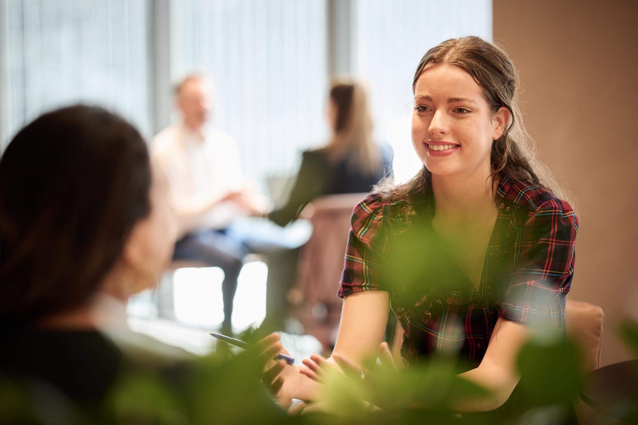 Office worker smiling at a co-worker opposite her