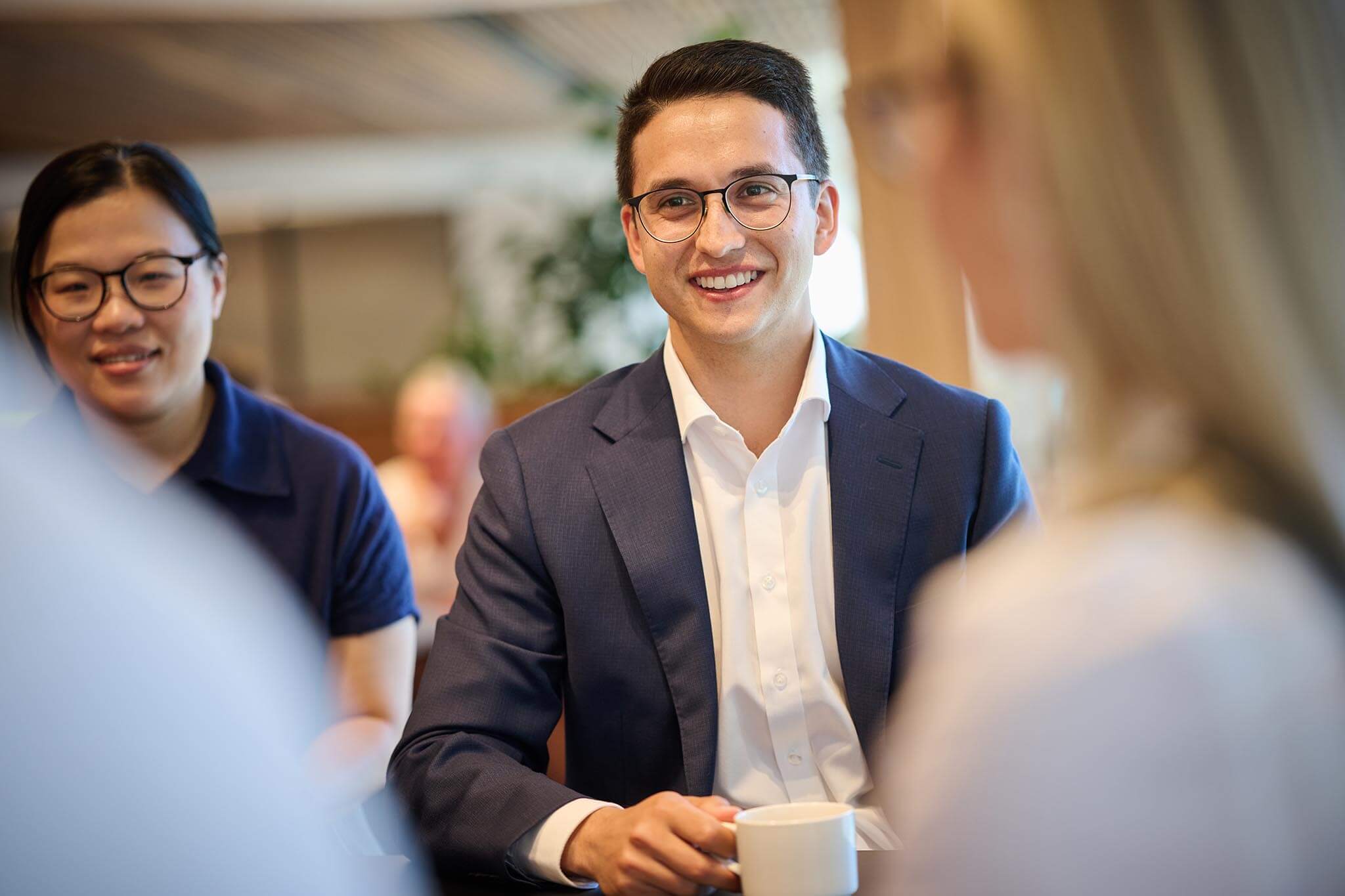 Office worker smiling at a colleague opposite him